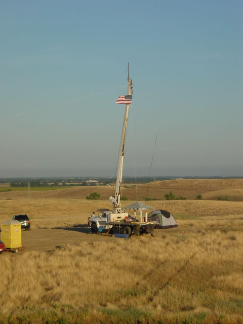 the crane truck with boom raised, antennas at the top