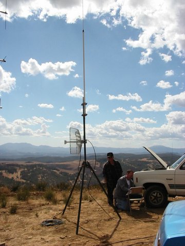 mast with dish antenna, Shayne works at laptop